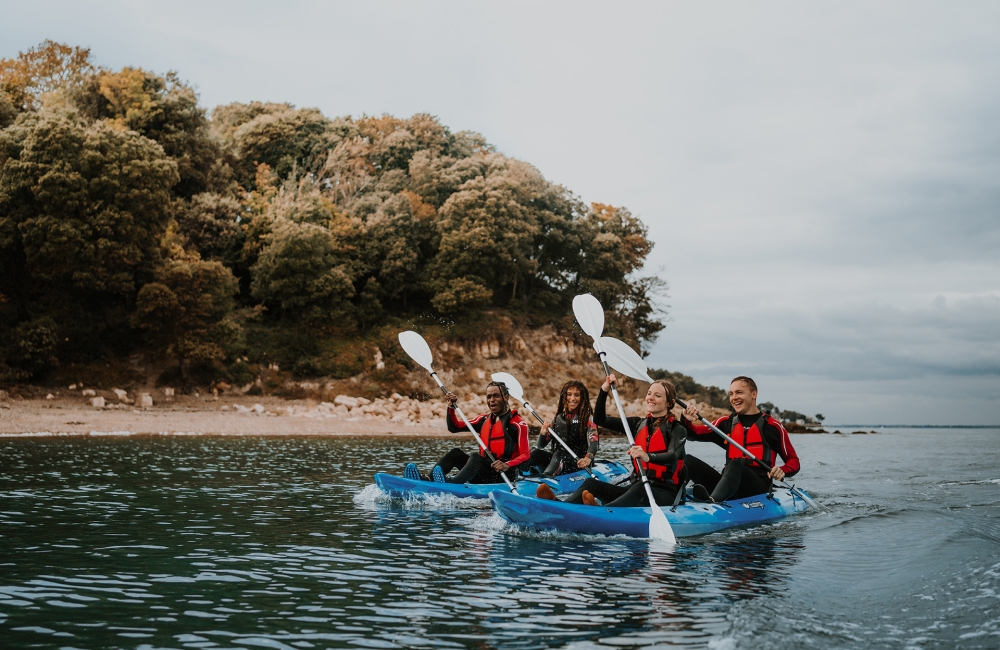 Group of friends on kayaks in the ocean 