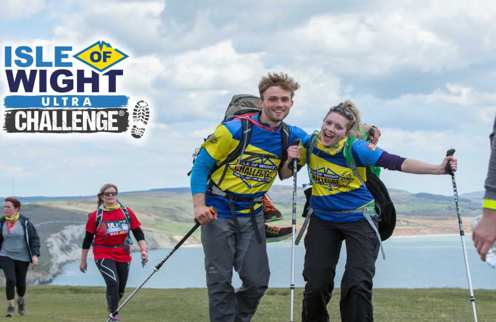 walkers celebrating with countryside and coastline in the background