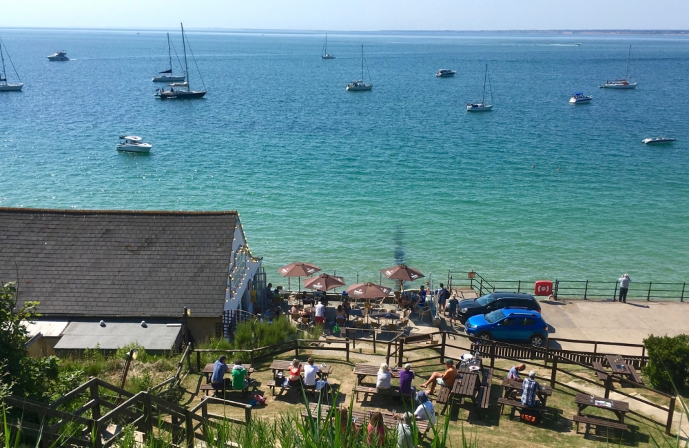 a view of the waterfront bar and restaurant with blue sea behind