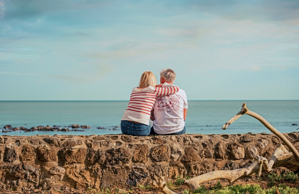 mature-couple-on-wall-sunset