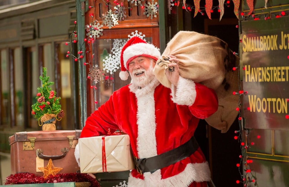 father christmas carrying a sack of toys at the station