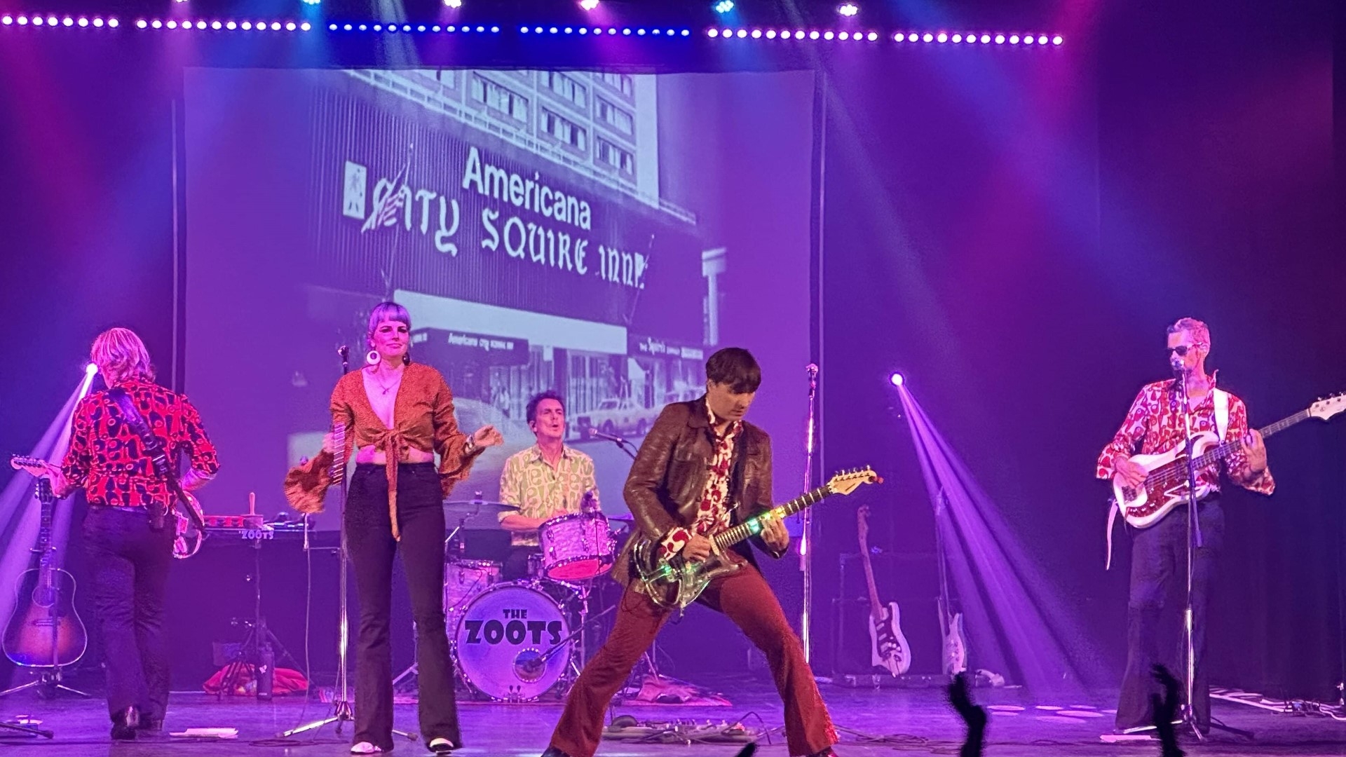 the zoots on stage with guitars and strobe lights