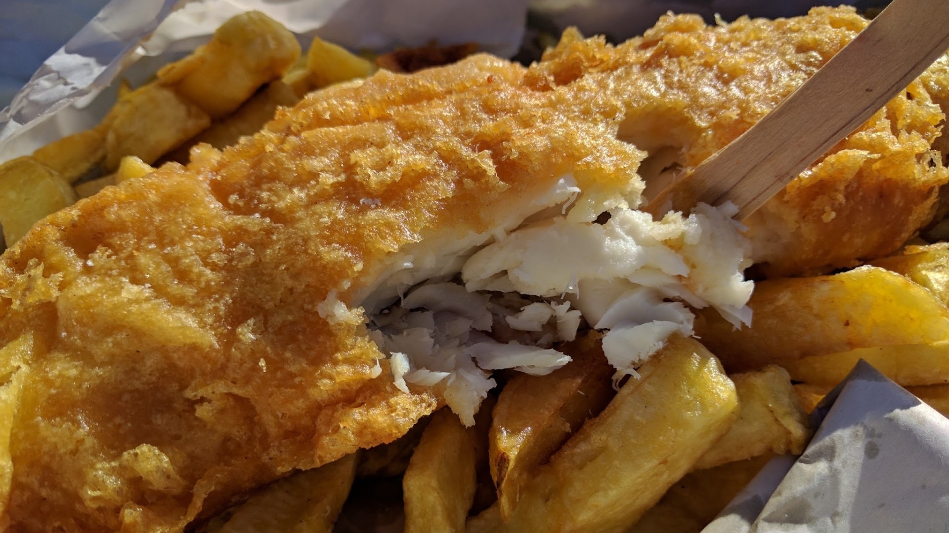 battered fish on top of golden chips