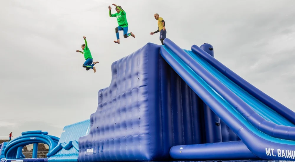 kids jumping from inflatable obstacle at the aqua park