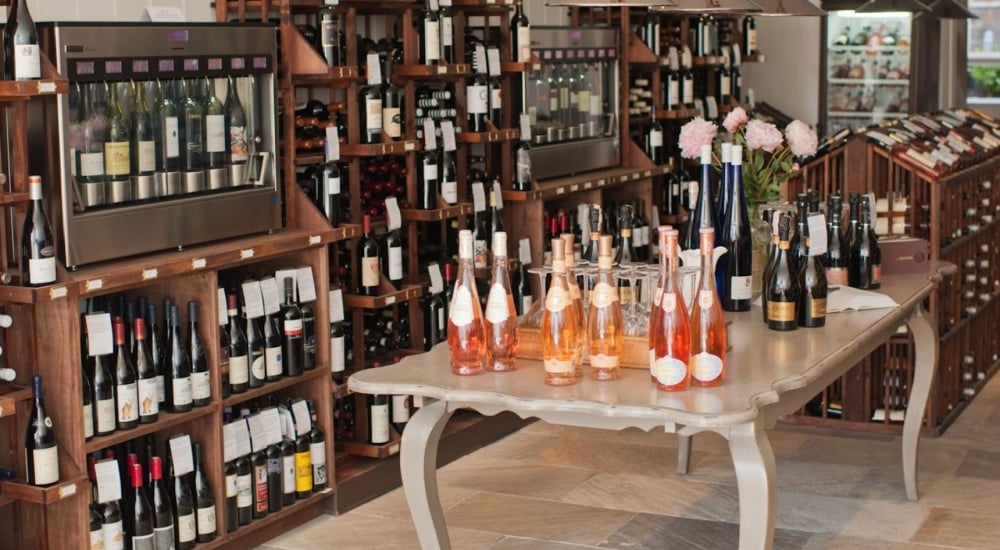 Inside Wine Therapy, bottles of wine on a table surrounded by shelves of wine bottles